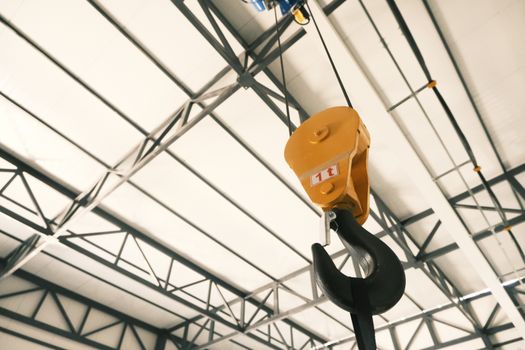Close-up of a yellow crane hook inside a modern industrial facility in Konya, Türkiye.