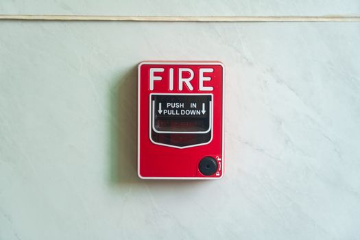 Image of a wall mounted red fire alarm device for safety alerts and emergency preparedness.